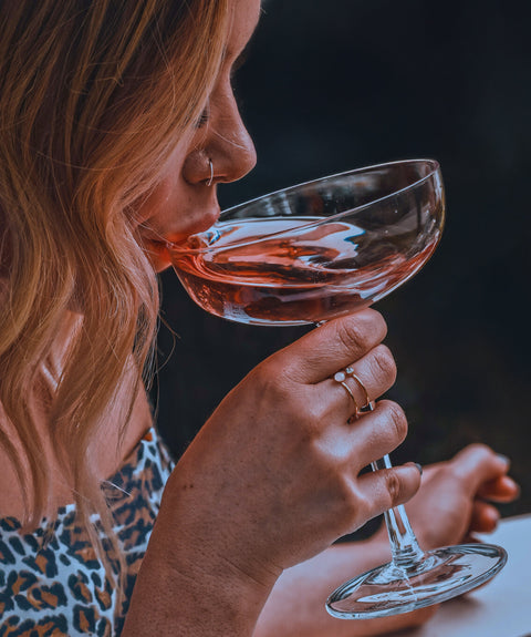 Women drinking a rose wine from a couple glass