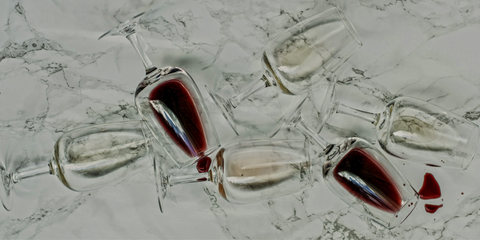 Empty and split wine glasses littered about that depict a good evening of wine tasting