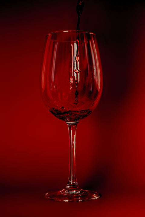 Red wine glass on a red background
